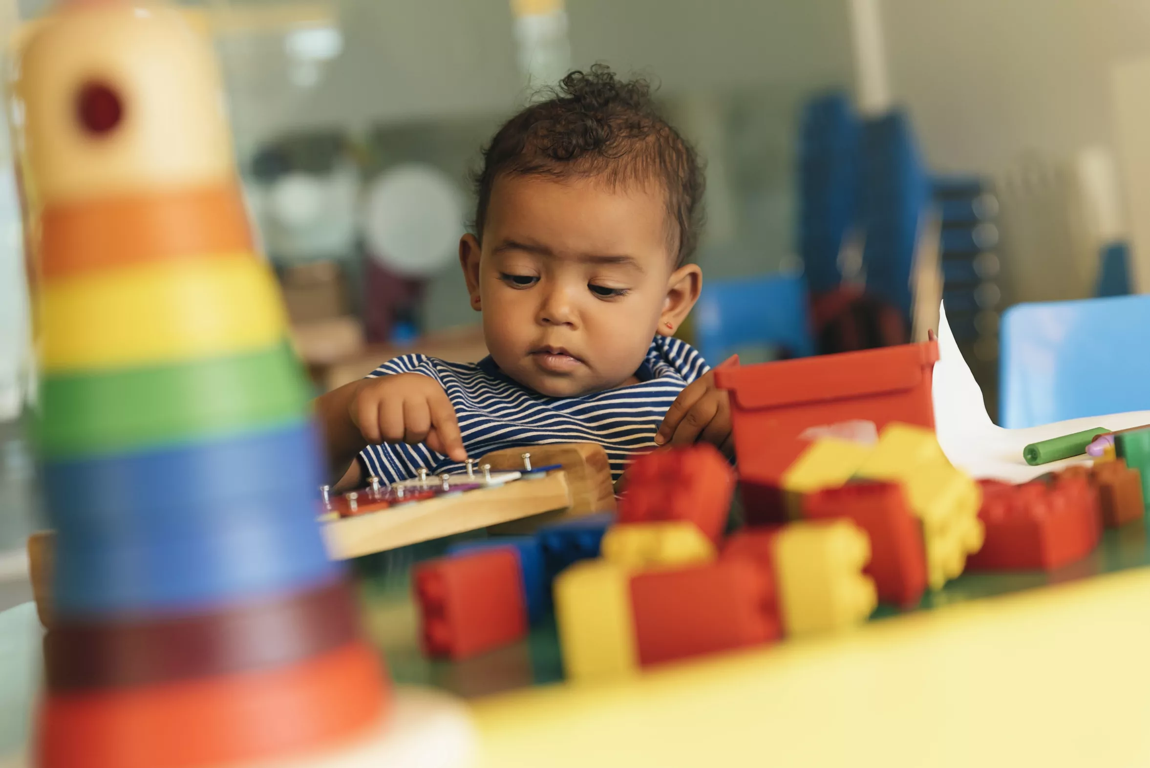 Joyeux-bebe-jouant-avec-des-blocs-de-jouets-a-l-ecole